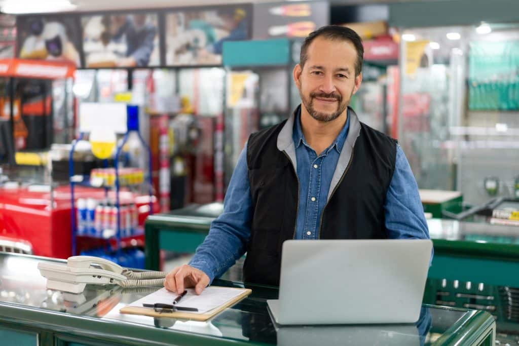 Business manager looking happy working at a hardware store